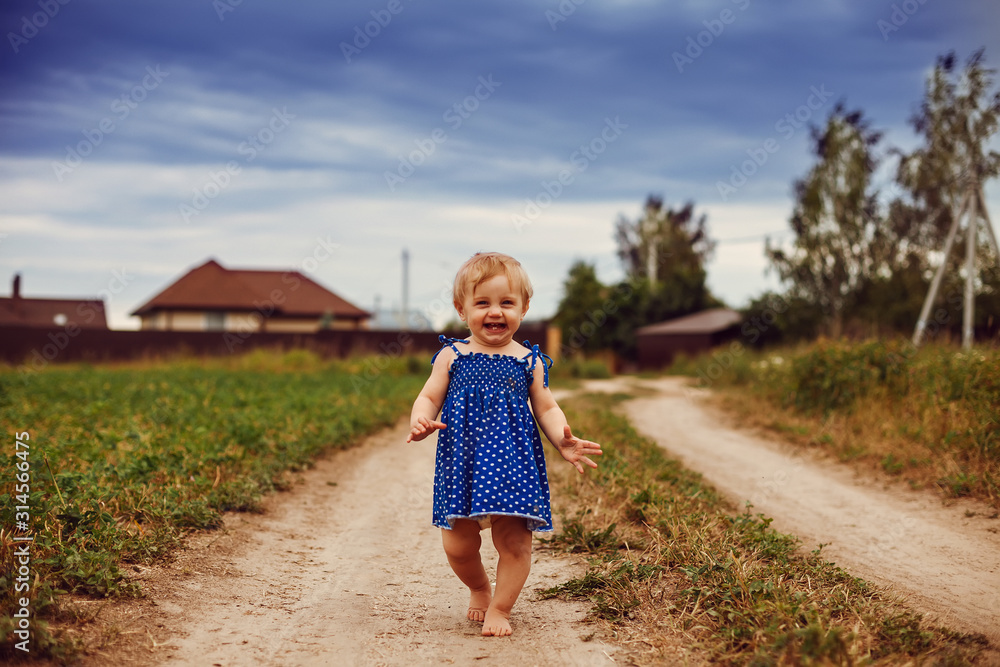 little one-year-old girl barefoot on country road. little one-year-old girl barefoot on country road.