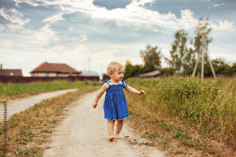 Toddler girl runing barefoot on village road. Toddler girl runing barefoot on village road.
