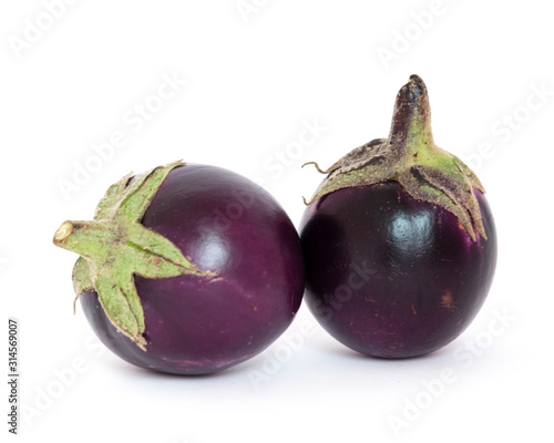 Studio shot of two organic violet round Thai eggplant isolated on white