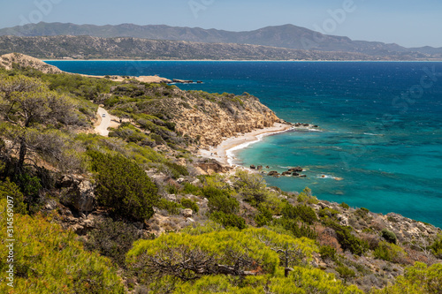 Scenic view at beach Akra Fourni nearby Monolithos at Rhodes island with green vegetation in the foreground and the aegean sea in the background