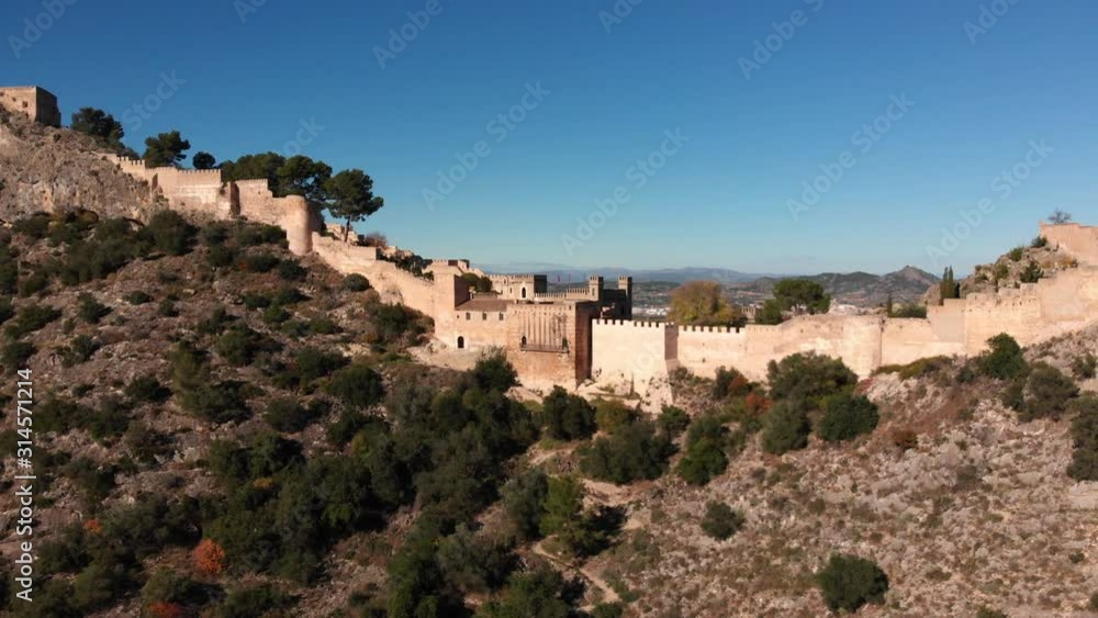Aerial lateral fly with dolly effect of an old medieval castle and the view of the mountains beyond the castle Aerial lateral fly with dolly effect of an old medieval castle and the view of the mountains beyond the castle