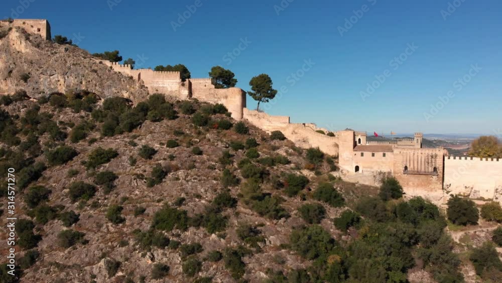 Aerial close by lateral view of an old medieval castle on a v shaped rocky mountain Aerial close by lateral view of an old medieval castle on a v shaped rocky mountain