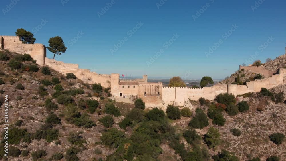 Close aerial fly towards an old medieval castle viewing the valley beyond it Close aerial fly towards an old medieval castle viewing the valley beyond it