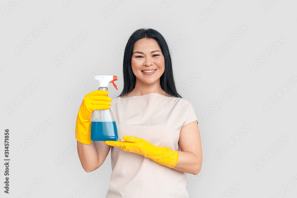 Freestyle. Asian woman in gloves standing isolated on white posing with spray smiling cheerful Freestyle. Asian woman in gloves standing isolated on white posing with spray smiling cheerful