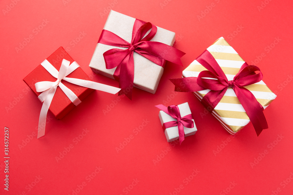 Gift boxes with bow on red background. Top view. Copy space. Gift boxes with bow on red background. Top view. Copy space.