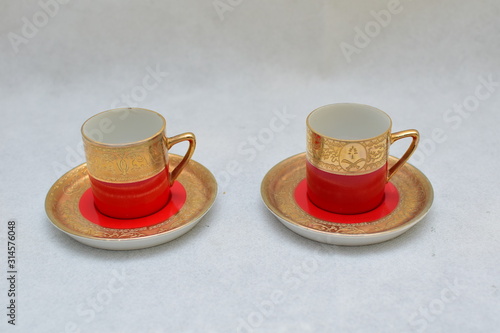 Mock up   design set of elegant and traditional colorful Red and gold traditional elegant coffee cup   Tea cup on cup s plate beside the hot tea jar container   design  drink-ware