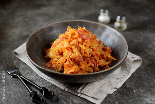 Braised cabbage with ham, onions and carrots. Traditional Russian food.