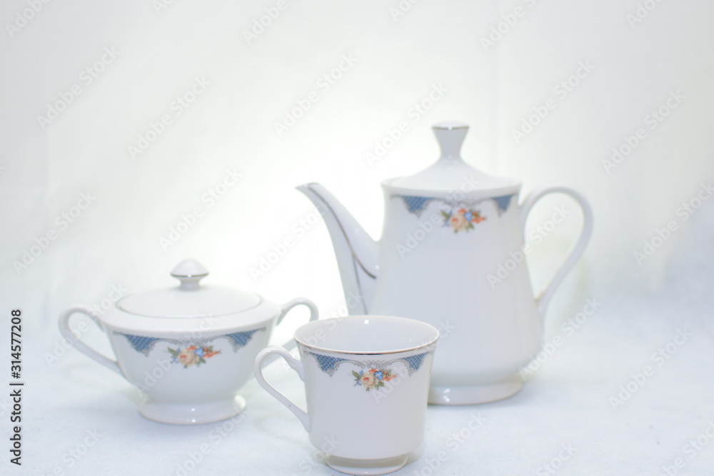Mock up / design set of elegant and traditional teapot colorful white and blue coffee cup & Tea cup on cup's plate beside the hot tea pot , design/ drink-ware isolated on white background Mock up / design set of elegant and traditional teapot colorful white and blue coffee cup & Tea cup on cup's plate beside the hot tea pot , design/ drink-ware isolated on white background