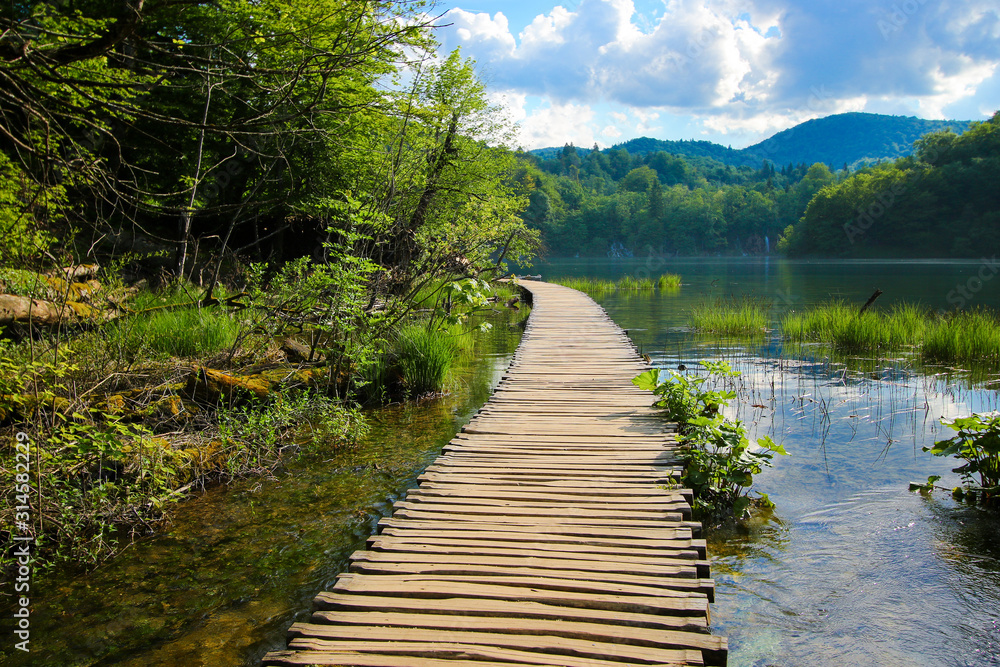 Wooden footbridge built above the blue waters of the Plitvice Lakes National Park in Croatia Wooden footbridge built above the blue waters of the Plitvice Lakes National Park in Croatia