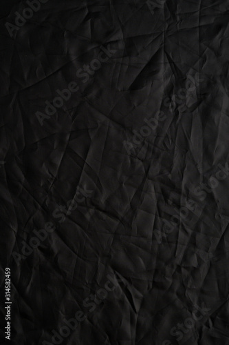 Texture of crumpled black fabric with a blue tint. Creative vintage background. Black flag.
