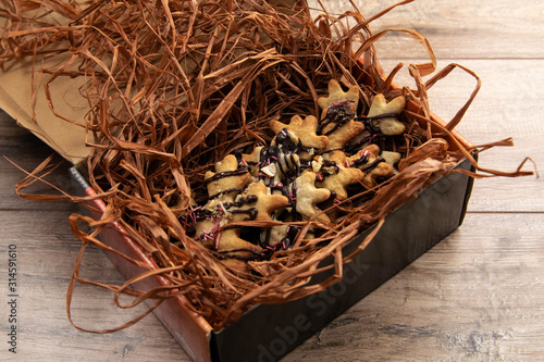 Handmade ginger biscuits in the form of snowflakes packed in a beautiful box with decorative grass photo