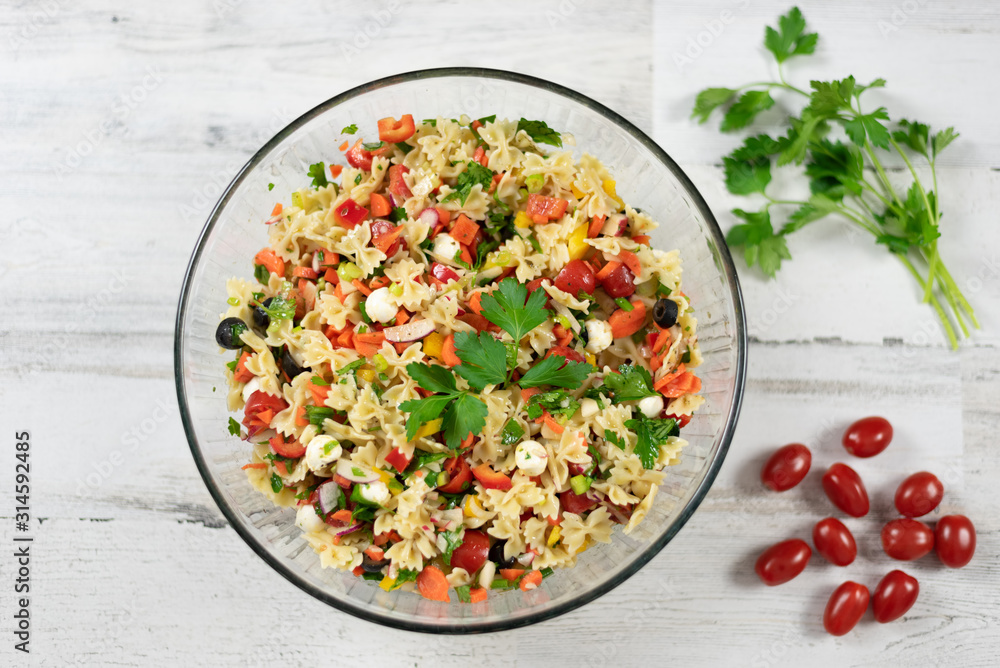 Top view of fresh pasta salad on white wood background Top view of fresh pasta salad on white wood background