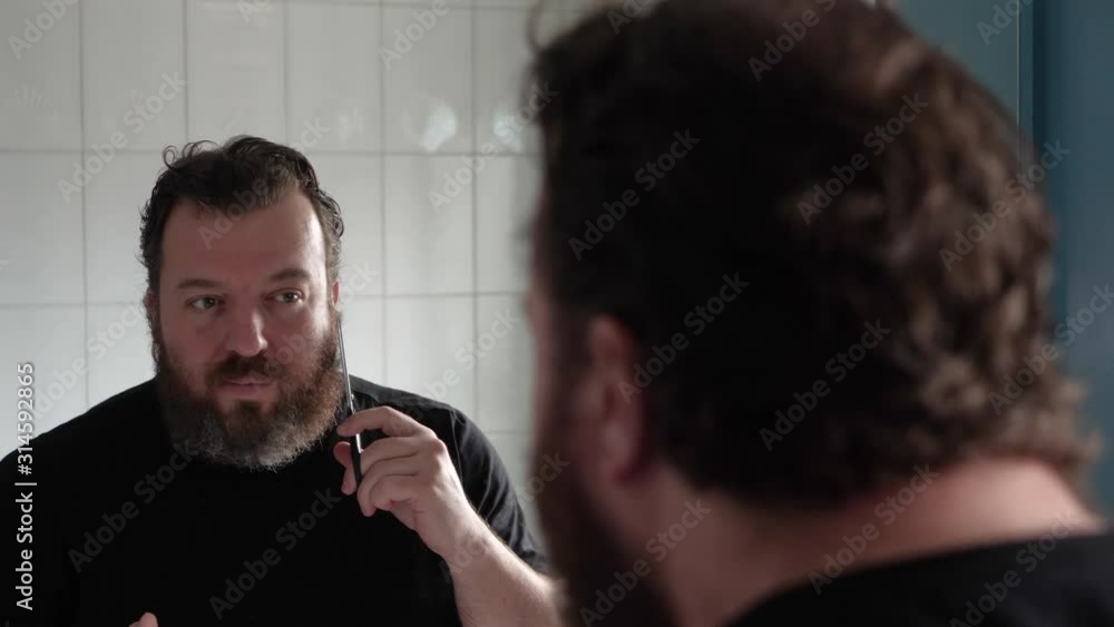 Man in the bathroom cuts the whiskers Man in the bathroom cuts the whiskers