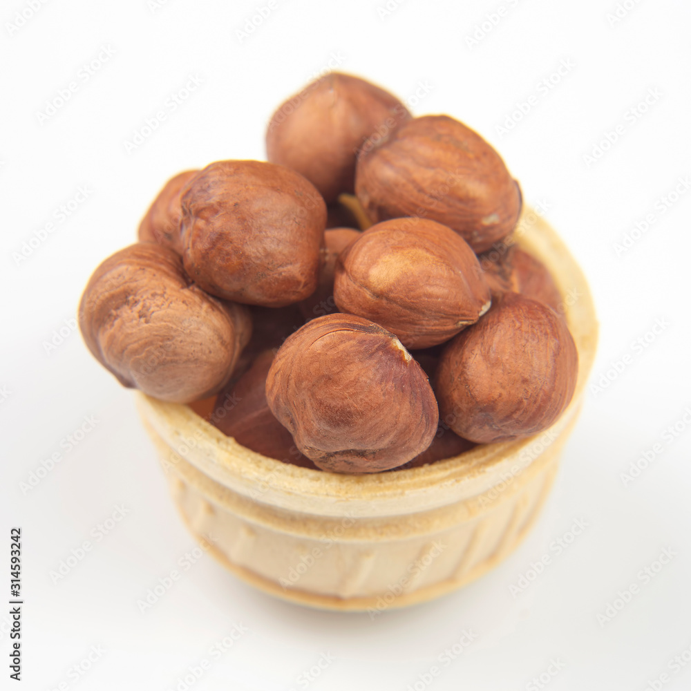 Different nuts in a waffle basket on a white background. Vitamin wholesome food. Different nuts in a waffle basket on a white background. Vitamin wholesome food.