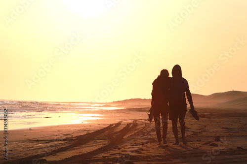 pareja caminando al atardecer con el sol en las espaldas