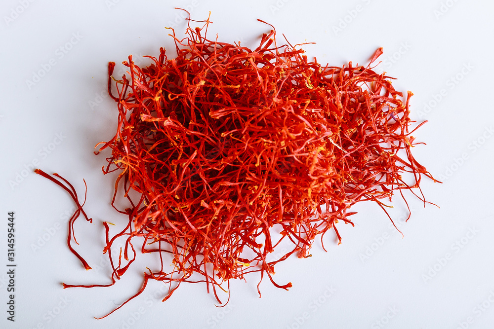 Naklejka premium Pile of red saffron threads isolated on a white background. Dear spice.