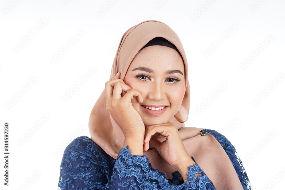A beautiful female Muslim model wearing dark blue modern kurung with hijab, a modern urban lifestyle apparel for Muslim women isolated on white background. Beauty and hijab fashion concept. A beautiful female Muslim model wearing dark blue modern kurung with hijab, a modern urban lifestyle apparel for Muslim women isolated on white background. Beauty and hijab fashion concept.