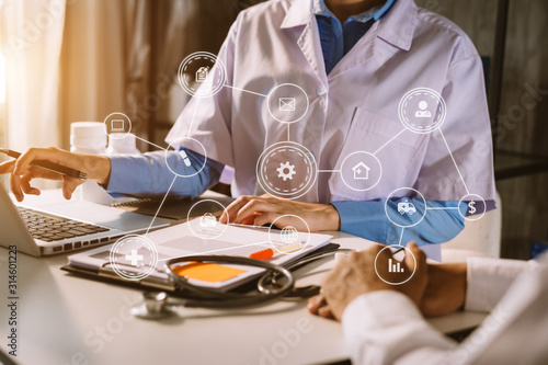 Medicine doctor hand working with modern computer and smart phone,digital tablet with his team on white desk as medical concept in morning light