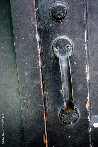 Old doorknob many times painted door