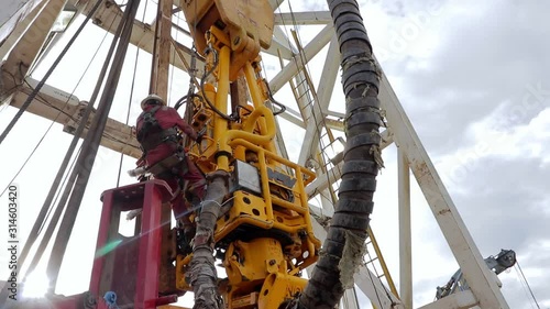 Close-up shot of oil rig operator assembling the top drive.