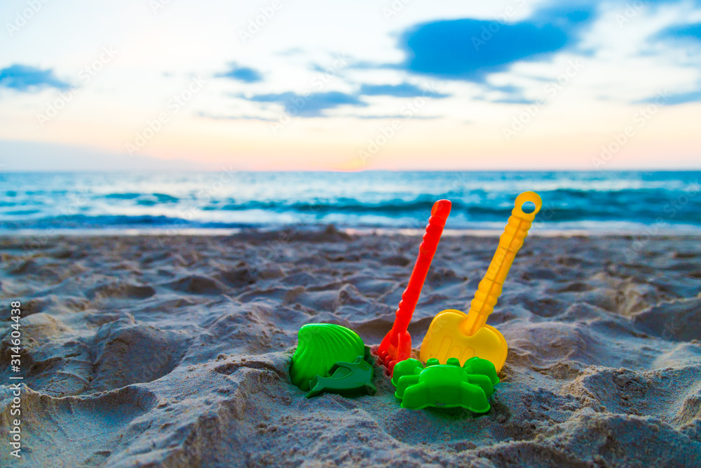 Colourful plastic baby toy on sand beach seaside