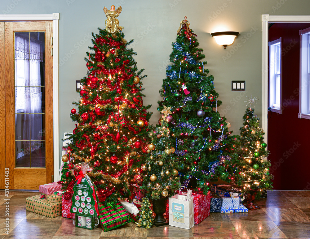Group or forest of artificial Christmas trees with gifts in family living  room