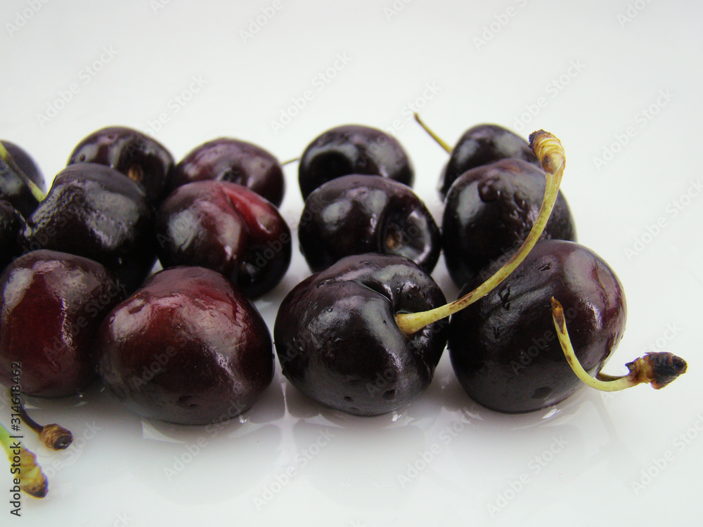 Fresh cherries with drops of water on a white background Fresh cherries with drops of water on a white background