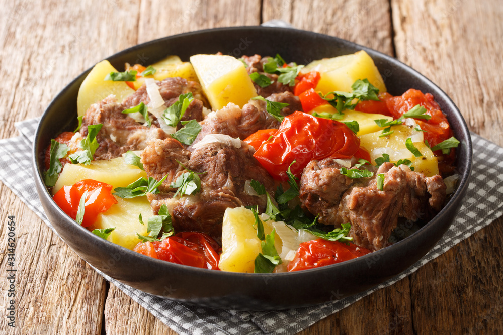 Slow cooked khashlama from meat with vegetables close-up in a plate on the table. horizontal Slow cooked khashlama from meat with vegetables close-up in a plate on the table. horizontal