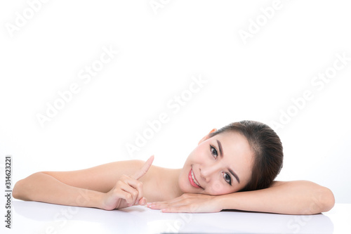 Beautiful young woman with clean fresh skin  Hair sleek  Proposing a product. Gestures for advertisement on pink background  Front view  with copy space.