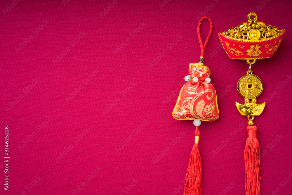 Chinese New Year decorations with red background with assorted festival decorations. Chinese characters means abundant of wealth, prosperity and luck. Flat lay.