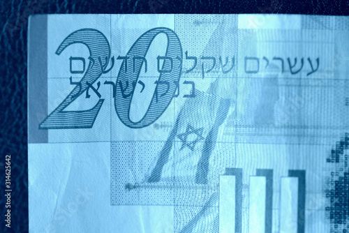 Twenty shekels banknote on a dark background close-up. Money background blue color toned