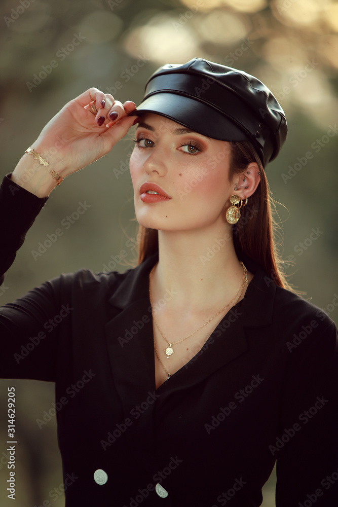 Portrait d'une jeune femme brune avec une casquette en cuir Portrait d'une jeune femme brune avec une casquette en cuir