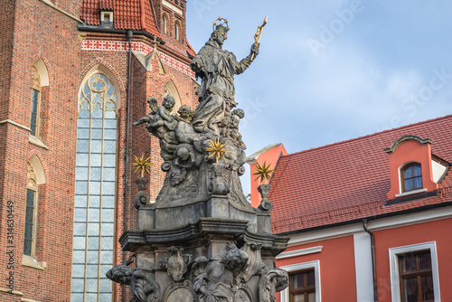 Statue of John Nepomucene in front of Holy Cross and Saint Bartholomew Church in Ostrow Tumski - historic part of Wroclaw city, Poland
