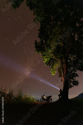 silhouette man looking milky way and stars on the sky at night in Thailand