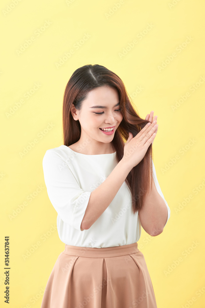 Beauty woman touch her long hair isolated on yellow background, asian beauty Beauty woman touch her long hair isolated on yellow background, asian beauty