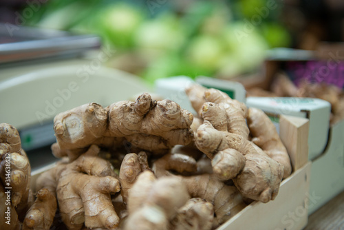 Bio organic fruits and vegetables, from organic farming, ginger roots piled up in cardboard box, between different fruits and vegetables in an unfocused backgroundood