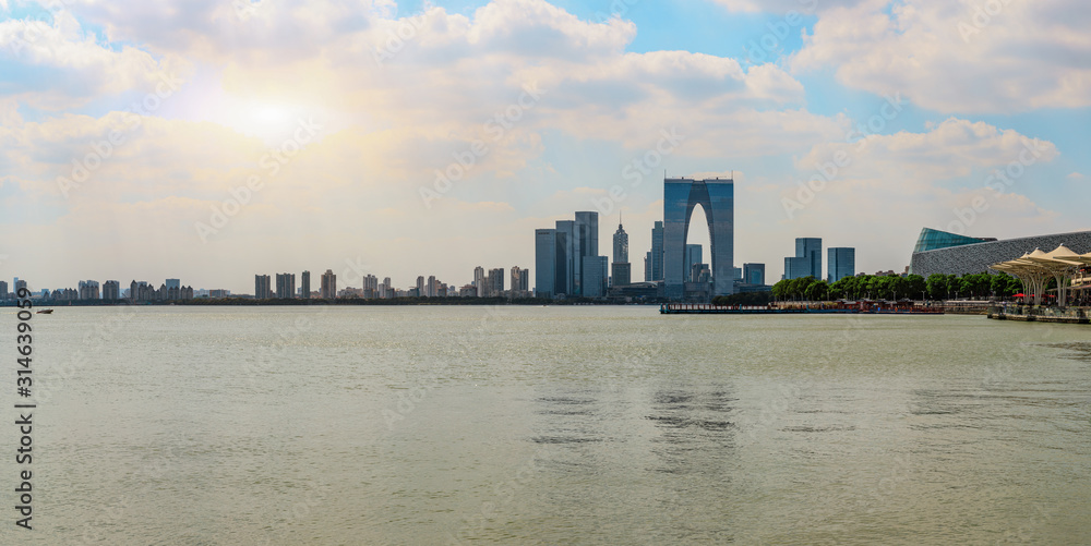 Obraz premium Beautiful city skyline and tranquil lake in Suzhou at sunset