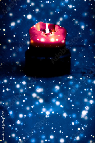 Photography Red holiday candle on blue sparkling snowing background, luxury branding design