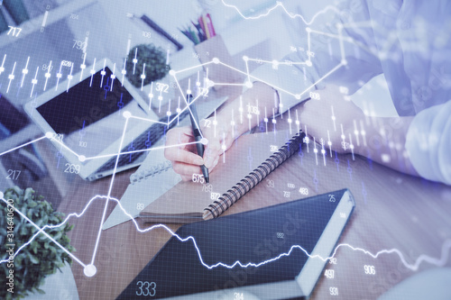 Financial graph displayed on woman's hand taking notes background. Concept of research. Double exposure