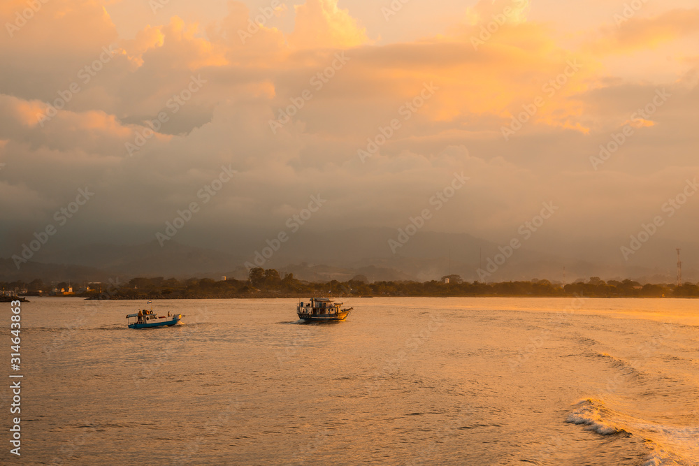 Roatan, Honduras »; January 2020: Fishing boats in the sea at sunset seen from the ferry heading to Roatan Island