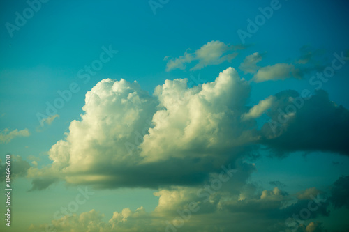 Large heavy clouds slowly float across the blue beautiful sky. Stunning landscape and view. Blue sky with white clouds. © Alik Mulikov