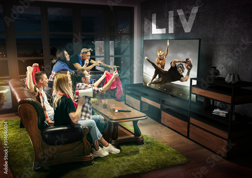 Group of friends watching TV, american football match, championship. Emotional men and women cheering for favourite team, look on fighting for ball. Concept of friendship, sport, competition, emotions photo