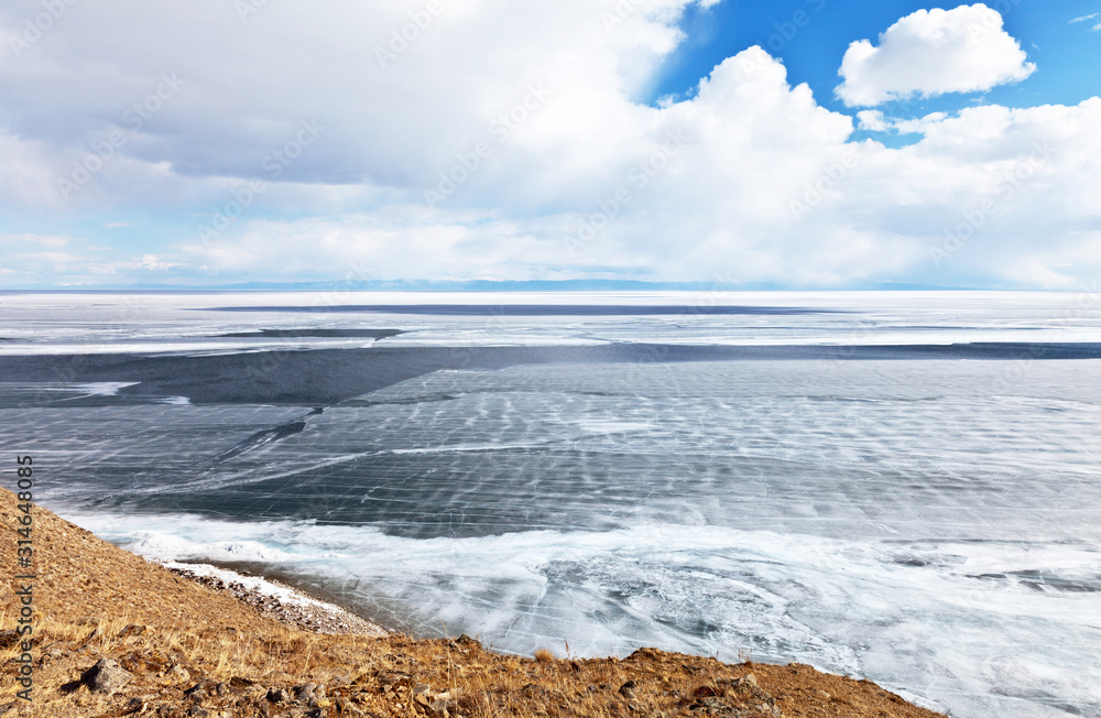 Lake Baikal on a spring sunny day. View of the ice drift and the destruction of the ice cover from Olkhon Island. Beautiful spring landscape. Natural background Lake Baikal on a spring sunny day. View of the ice drift and the destruction of the ice cover from Olkhon Island. Beautiful spring landscape. Natural background