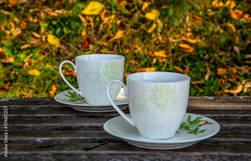 Two cups of tea stand on a wooden surface