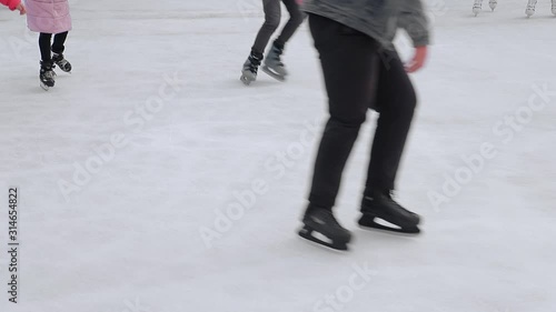 Tourists skate close-up on a large skating rink. Feet after skating which skating on a frozen lake.