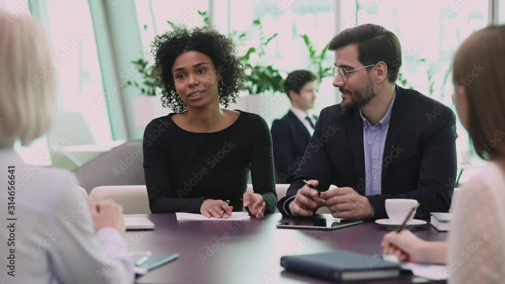 Diverse professional company representatives consulting clients at group meeting Diverse professional company representatives consulting clients at group meeting