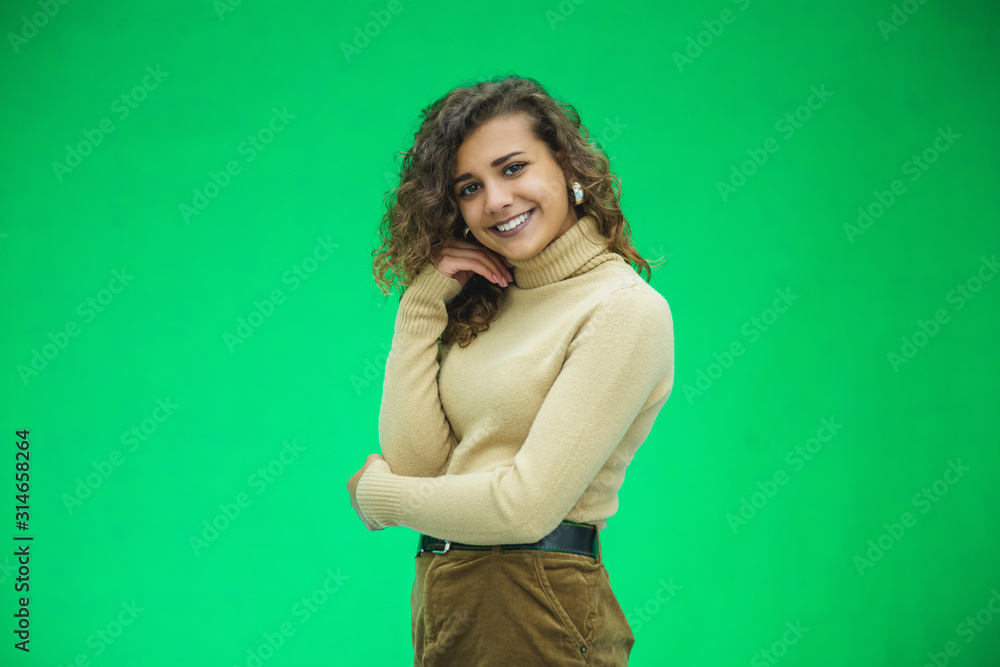 Portrait of gorgeous female model posing in white fashion clothes in studio over green background. Portrait of gorgeous female model posing in white fashion clothes in studio over green background.