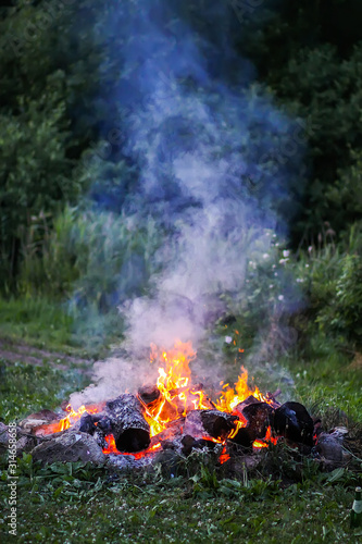 Bonfire at a camp in summer evening outdoors