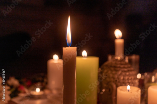 Close-up. Mandala made of burning candles  flowers  a grishna idol in the dark