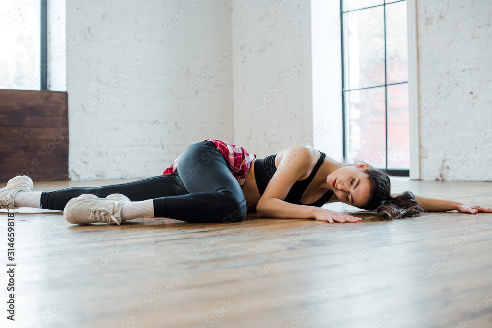 attractive girl lying on floor while dancing jazz funk in dance studio attractive girl lying on floor while dancing jazz funk in dance studio